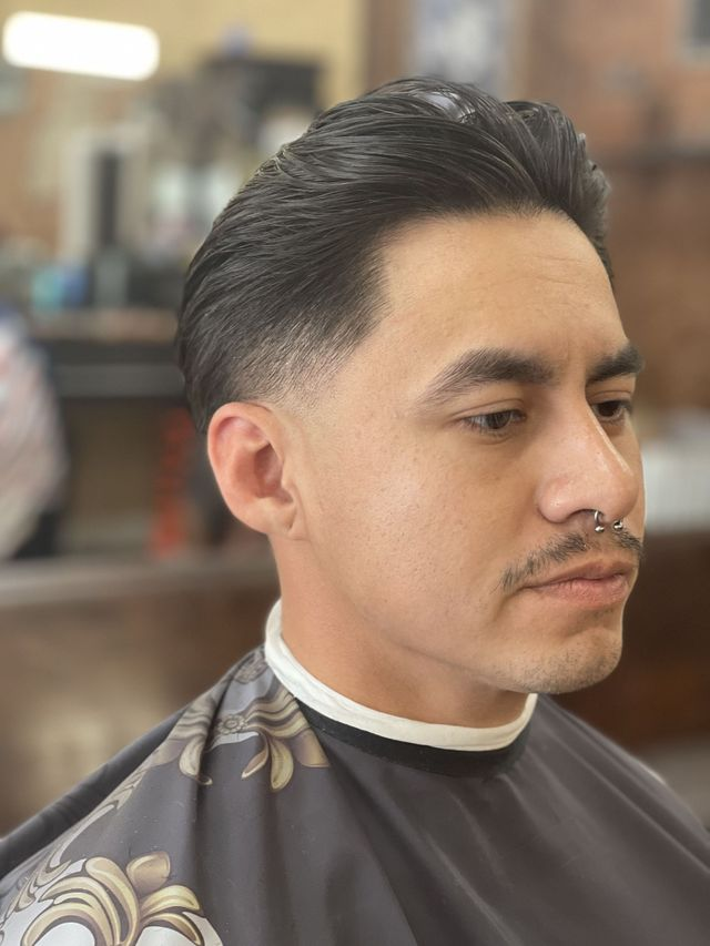 Low taper haircut with swept-back finish at JM Barber Co. in Lake Park, FL